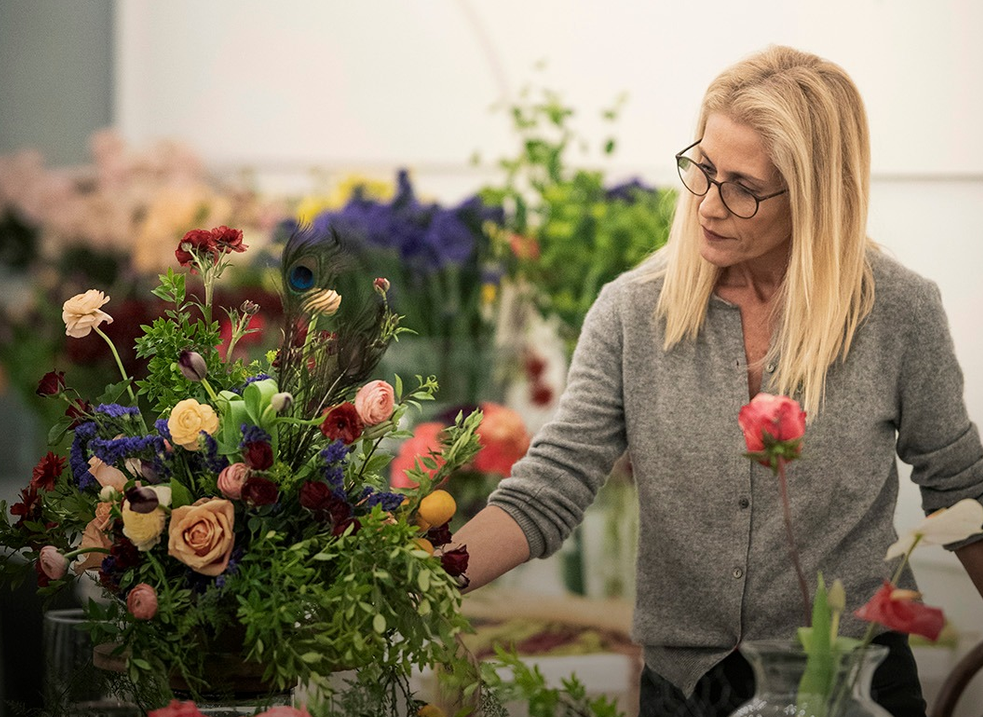 Lucia Milan compondo um arranjo floral em seu atelier